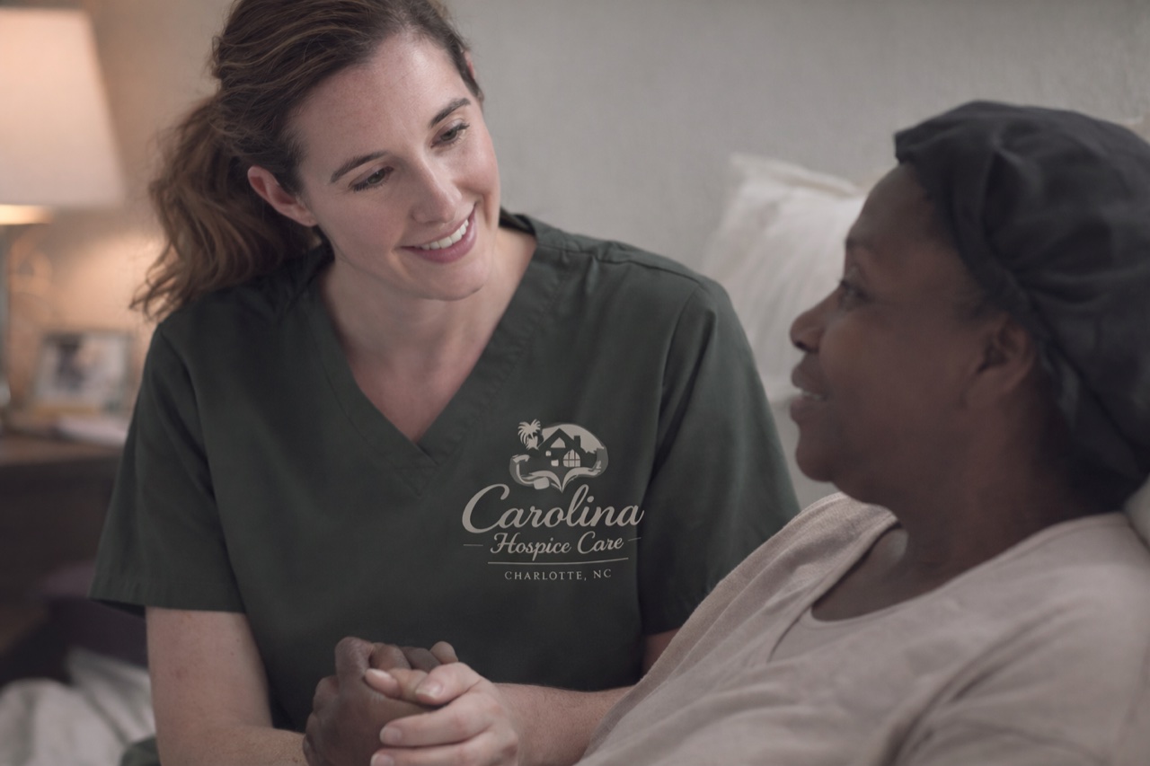 A caregiver holding a patient's hand.